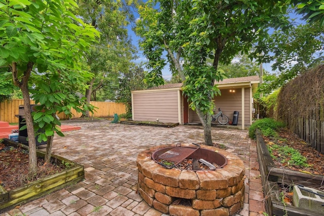 view of patio / terrace featuring an outbuilding and a fire pit