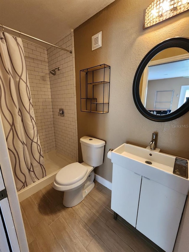 bathroom with toilet, vanity, and a shower with shower curtain