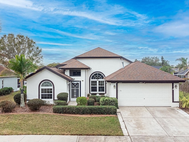 1515 Lions Club Dr, Brandon, FL 33511 - view of front of property featuring a garage, driveway, a front yard, stucco siding, and a shingled roof