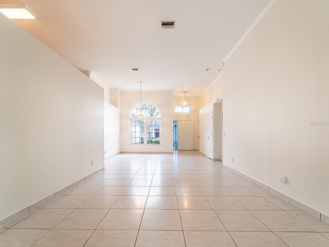 spare room featuring light tile patterned floors and ornamental molding