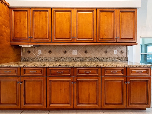 kitchen featuring decorative backsplash and light stone counters