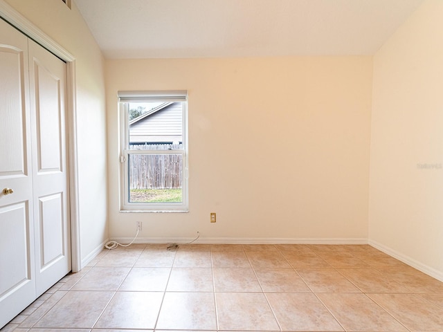 unfurnished bedroom featuring light tile patterned floors and a closet