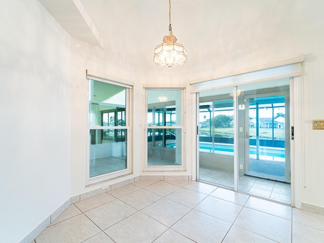 empty room featuring light tile patterned floors and a notable chandelier