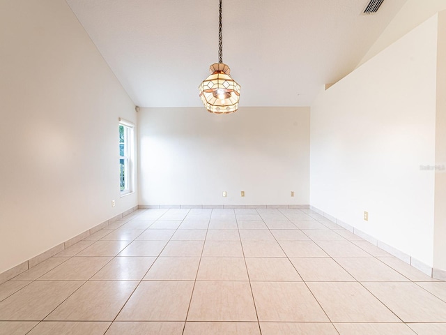 tiled empty room featuring a chandelier and lofted ceiling