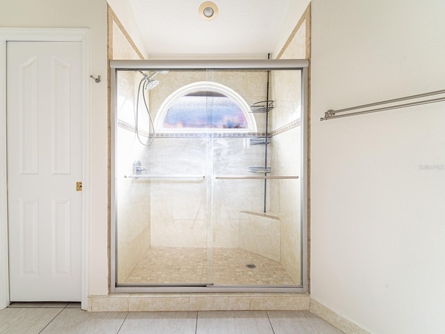 bathroom with tile patterned flooring and a shower with shower door