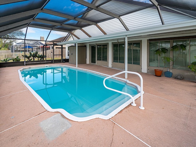 view of pool with glass enclosure and a patio area