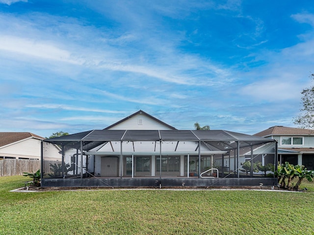 back of property with a lawn and a lanai