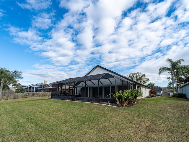 back of property with a yard and a lanai