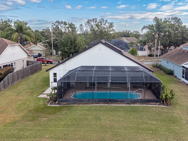 view of swimming pool with glass enclosure, a patio area, and a yard