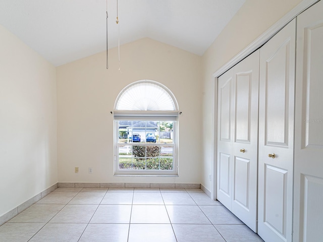 1515 Lions Club Dr, Brandon, FL 33511 - unfurnished bedroom with light tile patterned floors, lofted ceiling, a closet, and baseboards