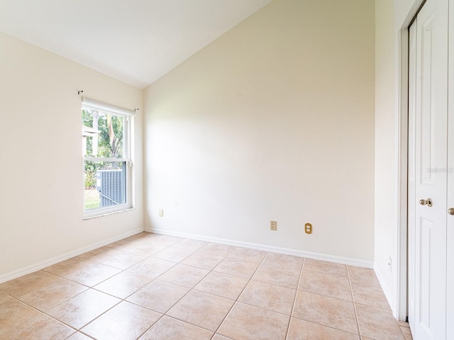 1515 Lions Club Dr, Brandon, FL 33511 - spare room featuring lofted ceiling, light tile patterned flooring, and baseboards