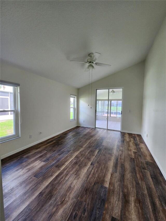 1515 Lions Club Dr, Brandon, FL 33511 - empty room with dark wood-style flooring, lofted ceiling, a ceiling fan, and baseboards