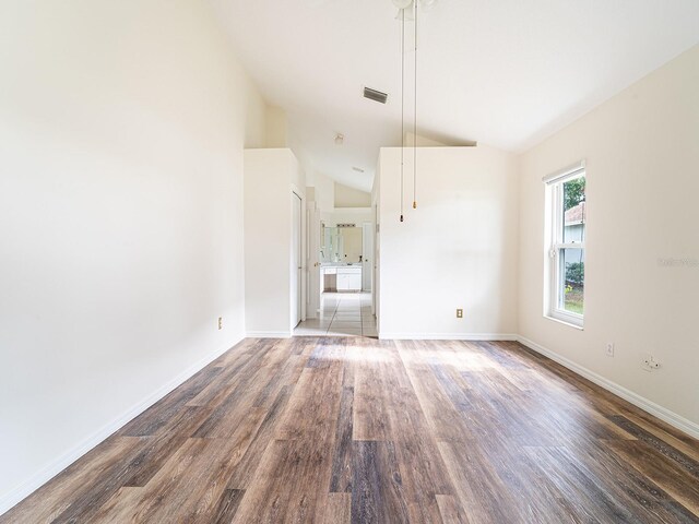 1515 Lions Club Dr, Brandon, FL 33511 - empty room featuring vaulted ceiling, wood finished floors, and baseboards