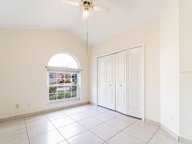 1515 Lions Club Dr, Brandon, FL 33511 - unfurnished bedroom with light tile patterned floors, a closet, lofted ceiling, ceiling fan, and baseboards