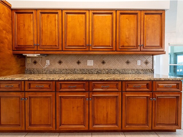 1515 Lions Club Dr, Brandon, FL 33511 - kitchen featuring light stone countertops, tasteful backsplash, and brown cabinets
