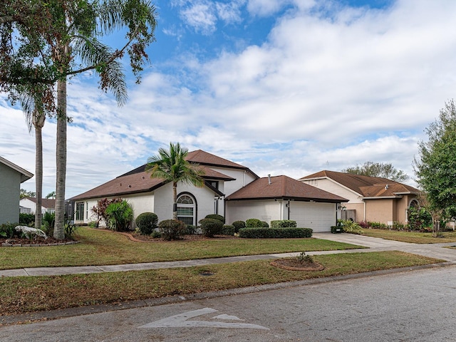 1515 Lions Club Dr, Brandon, FL 33511 - view of front of house with concrete driveway, a garage, a front lawn, and stucco siding