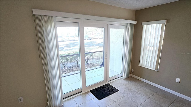 doorway to outside with light tile patterned floors