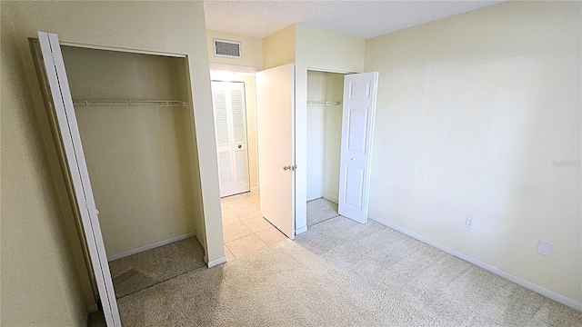 unfurnished bedroom featuring light colored carpet and a textured ceiling