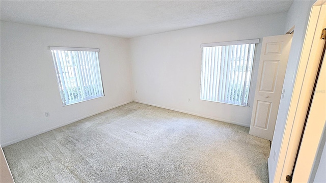 unfurnished room with light carpet and a textured ceiling