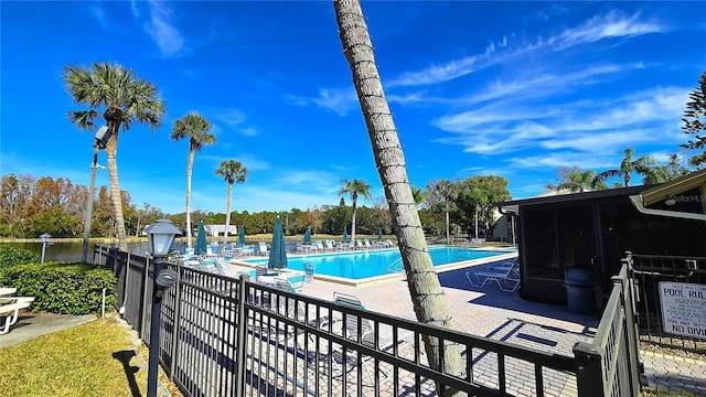 view of pool with a patio and a water view