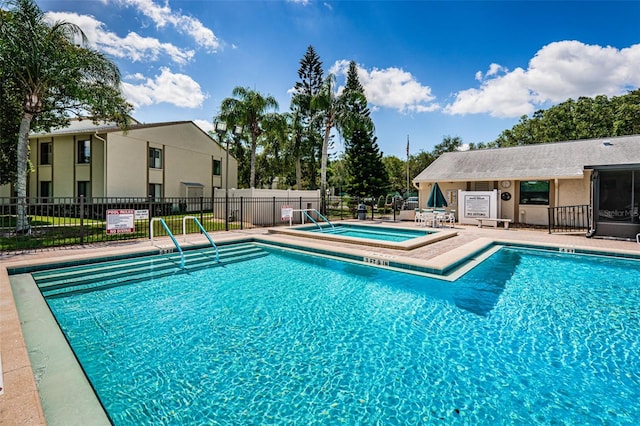 view of swimming pool with a community hot tub and a patio area