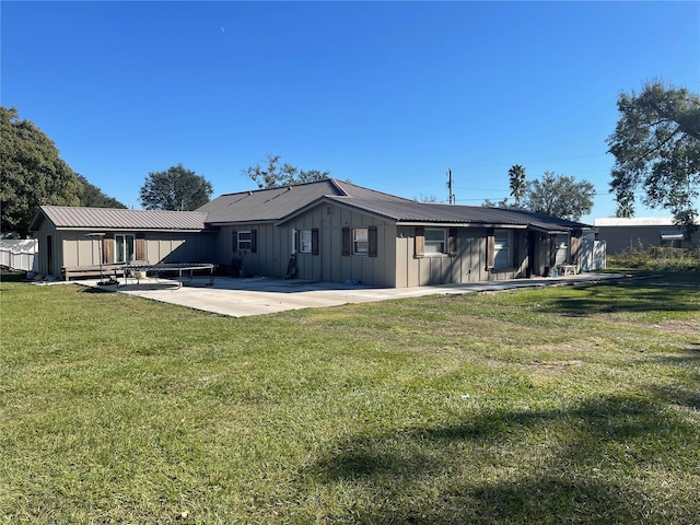 back of property with a lawn and a patio area