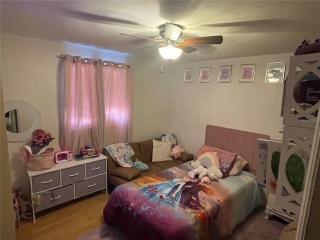 bedroom featuring hardwood / wood-style flooring, ceiling fan, and a textured ceiling