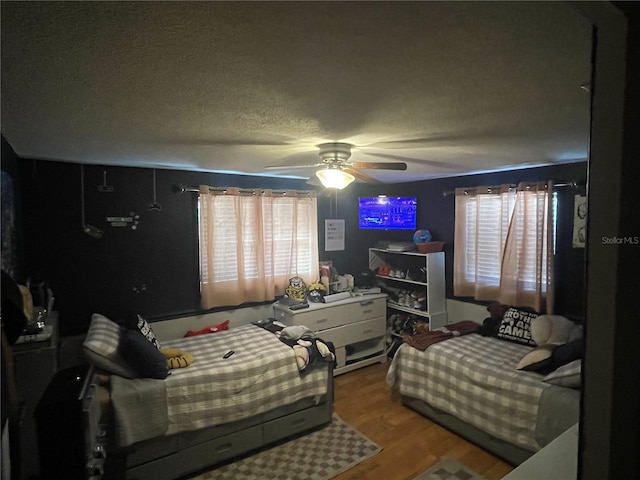 bedroom featuring ceiling fan, a textured ceiling, and hardwood / wood-style flooring