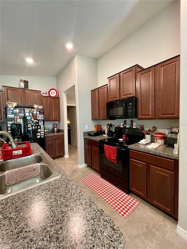 kitchen with a textured ceiling, sink, light tile patterned floors, and black appliances