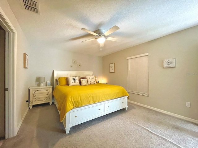 carpeted bedroom featuring ceiling fan and a textured ceiling