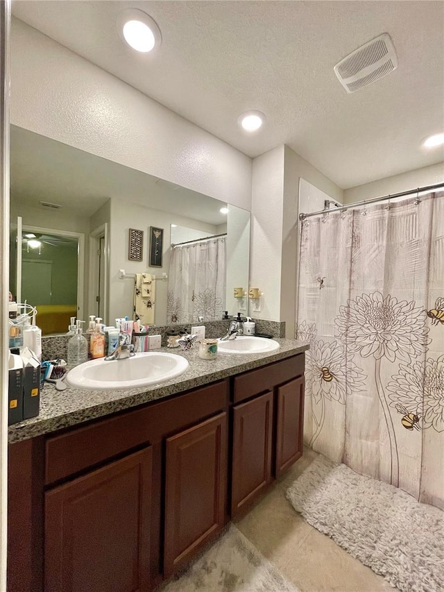 bathroom featuring tile patterned floors, vanity, and a textured ceiling