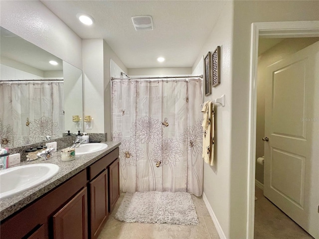 bathroom featuring tile patterned floors, vanity, and a textured ceiling