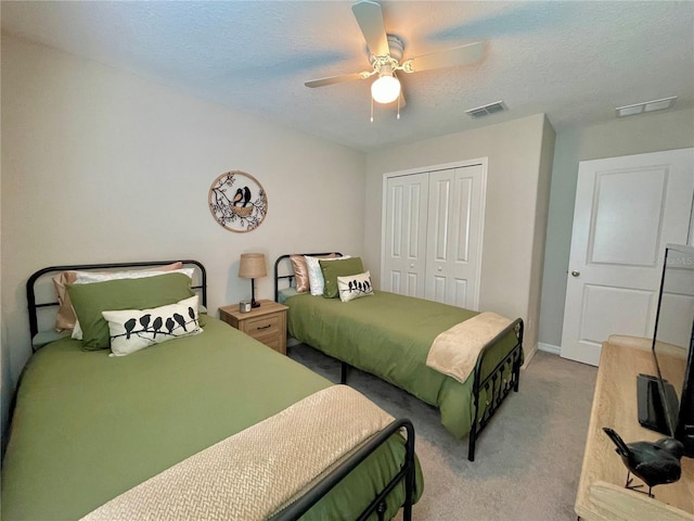 bedroom featuring ceiling fan, carpet floors, a textured ceiling, and a closet