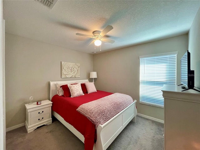 carpeted bedroom featuring ceiling fan and a textured ceiling