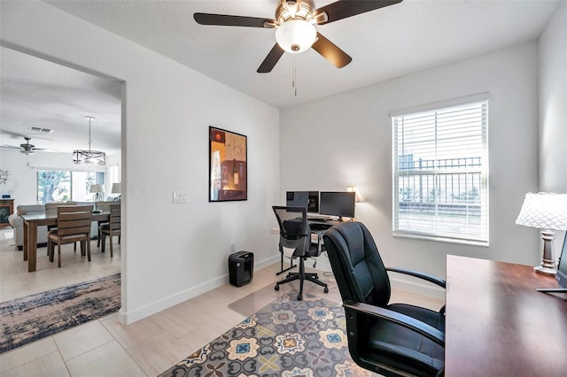 tiled office featuring ceiling fan and a healthy amount of sunlight