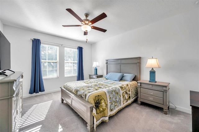 carpeted bedroom featuring ceiling fan and a textured ceiling