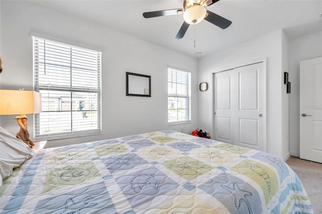 carpeted bedroom with ceiling fan and a closet