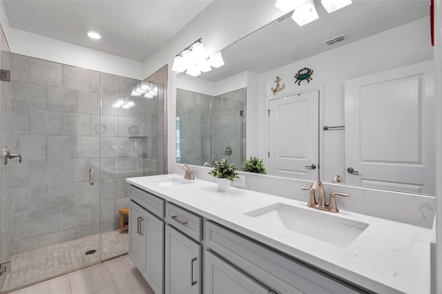 bathroom with tile patterned flooring, vanity, and a shower with shower door