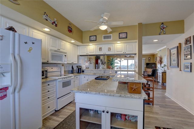 kitchen featuring a center island, white appliances, light hardwood / wood-style flooring, ceiling fan, and white cabinetry