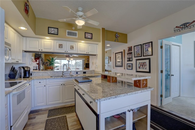 kitchen featuring white cabinets, white appliances, a center island, and sink