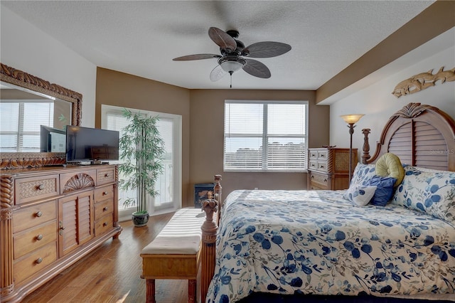 bedroom with ceiling fan, a textured ceiling, and light wood-type flooring