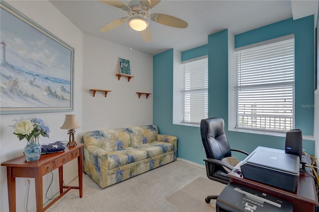 carpeted office with a textured ceiling and ceiling fan