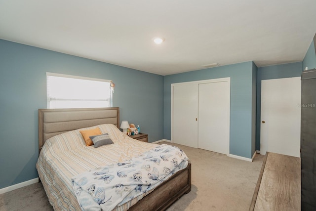 bedroom with light carpet and a closet