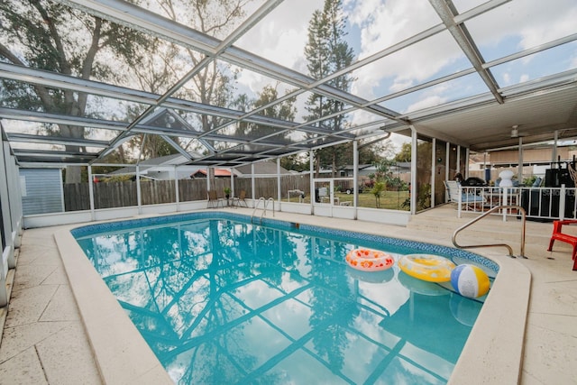 view of swimming pool featuring glass enclosure and a patio area