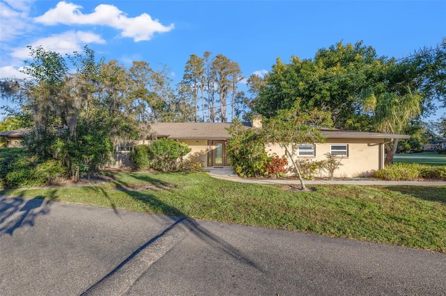 ranch-style home with a front lawn