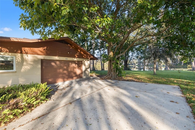 view of property exterior with a garage and a lawn