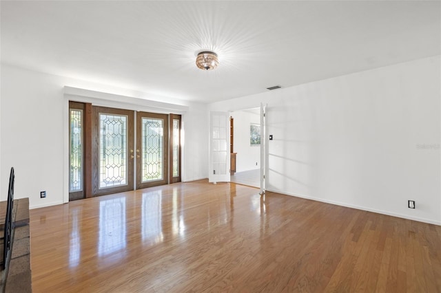 foyer with wood-type flooring and french doors