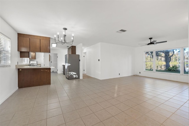 kitchen with kitchen peninsula, light tile patterned floors, decorative light fixtures, and a wealth of natural light