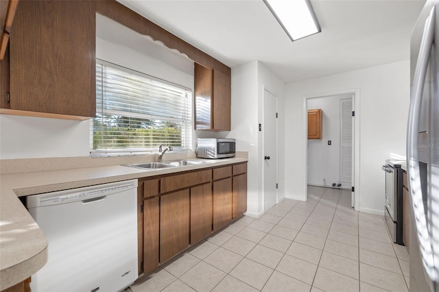 kitchen with sink, light tile patterned floors, and stainless steel appliances