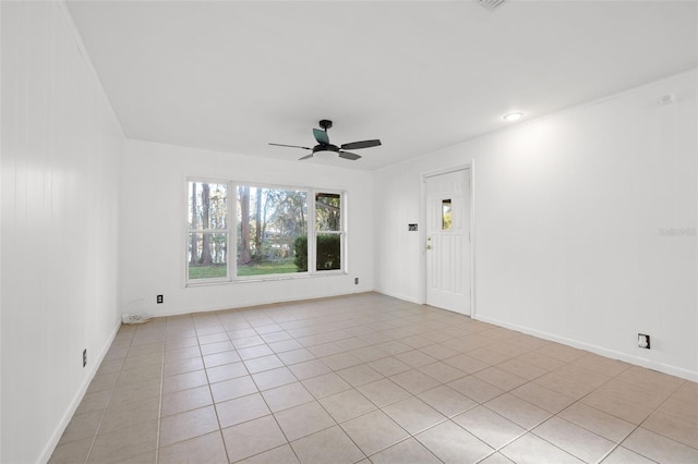 spare room with ceiling fan, light tile patterned flooring, and ornamental molding